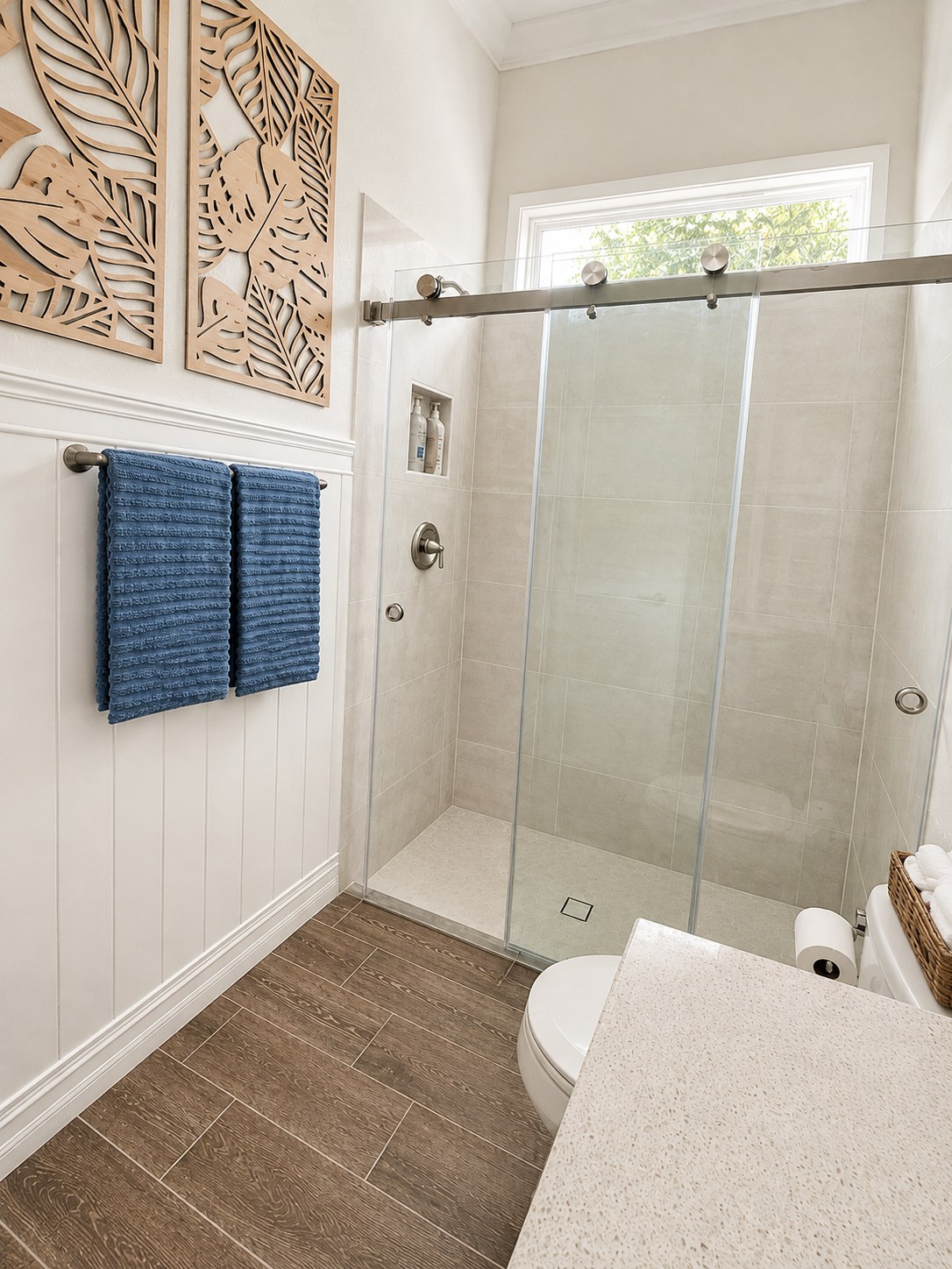 Finished bathroom with sliding glass shower door and wood-look tile floor