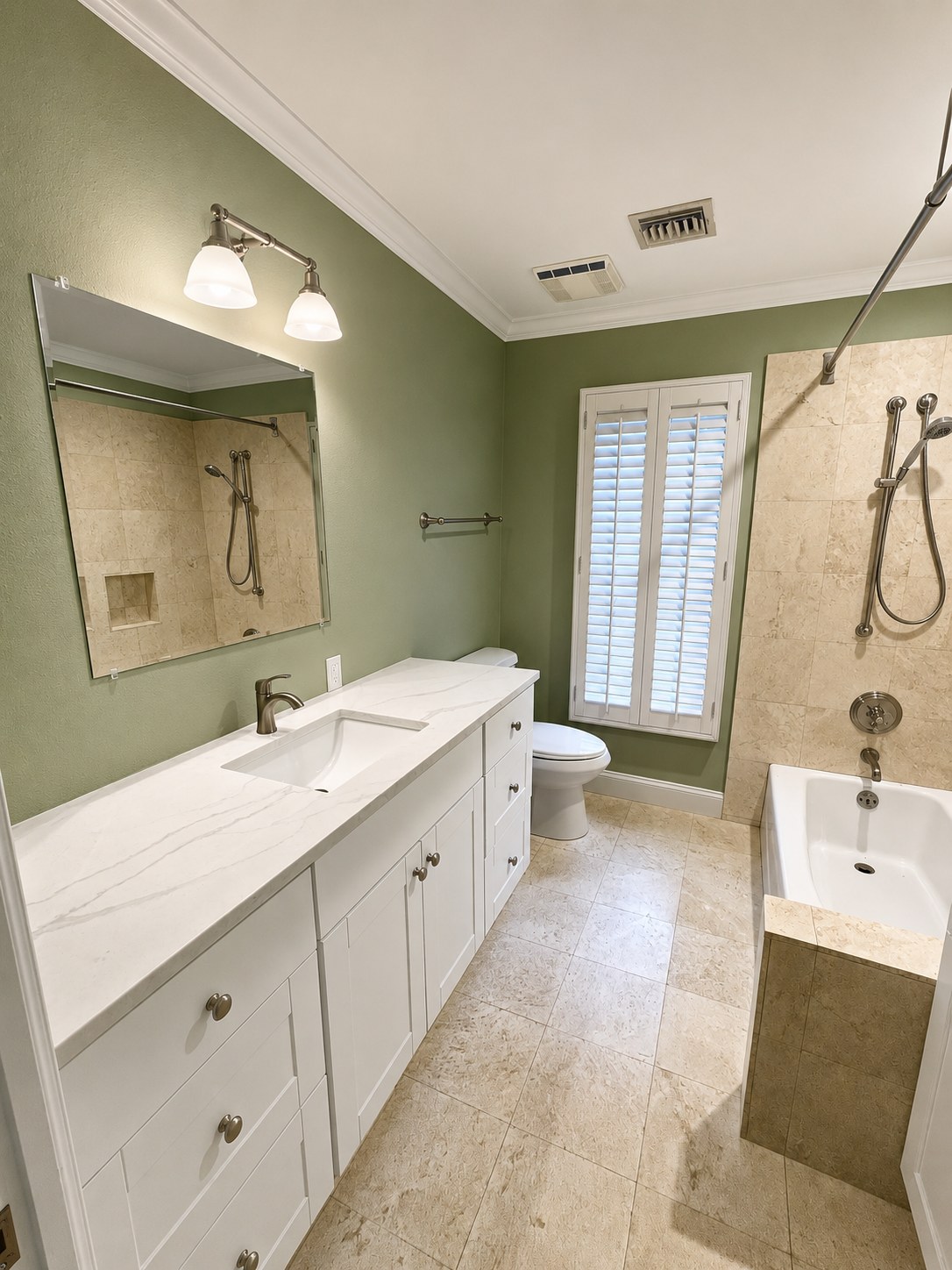 Finished bathroom with sage green walls, marble-look vanity, and tile tub surround