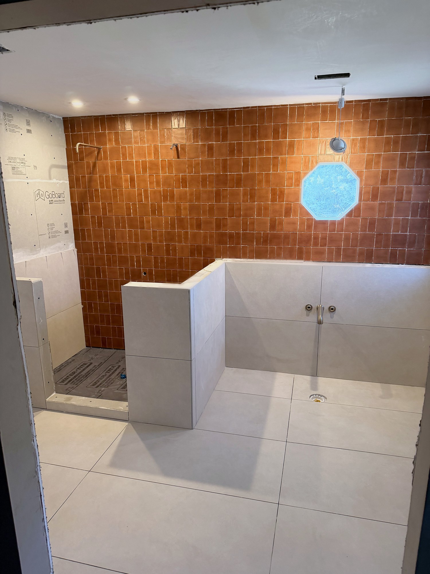 Terracotta-tile shower in progress, fixtures not yet installed