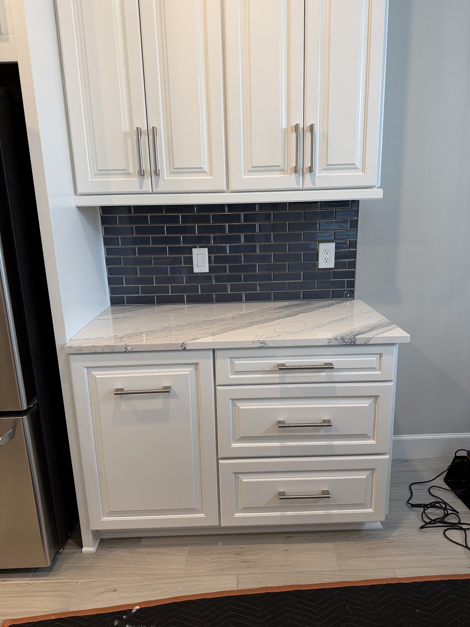 A second kitchen remodel in progress: navy subway tile backsplash going in