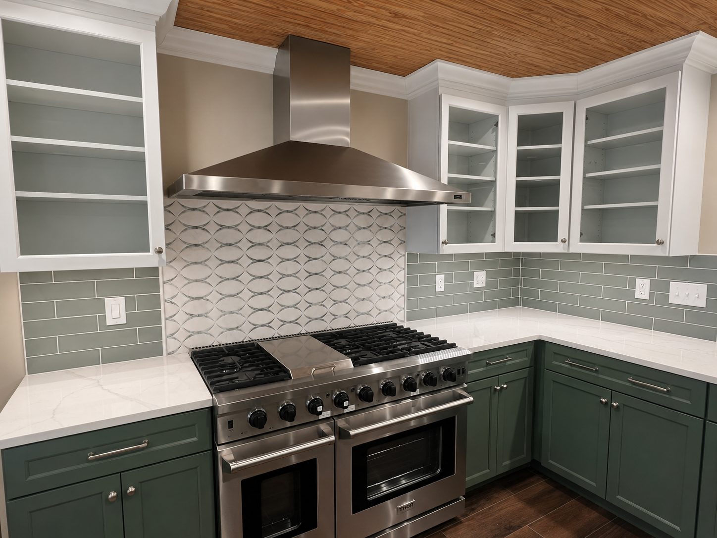 Finished kitchen remodel with sage green cabinetry, quartz counters, and a professional range