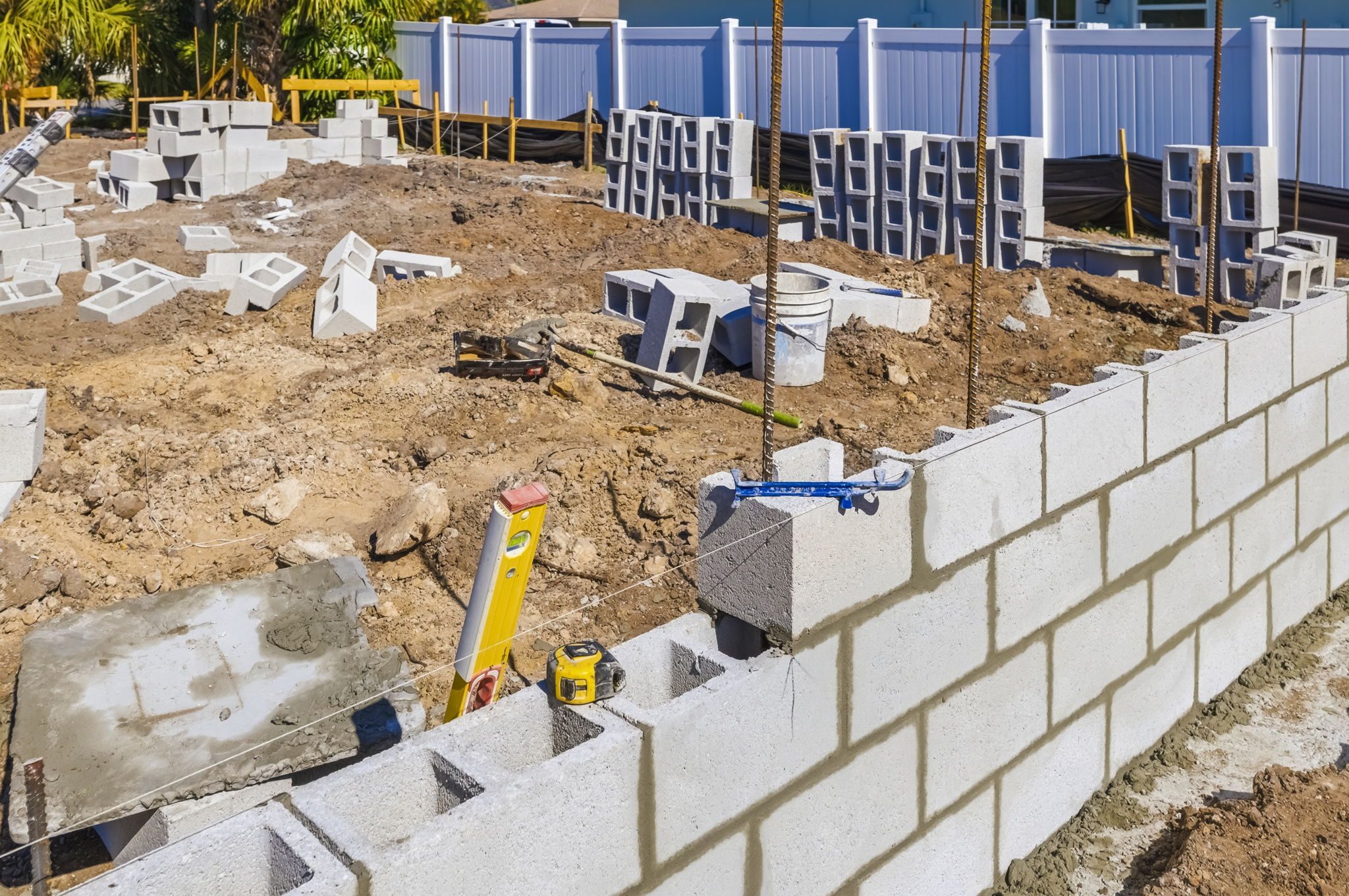 Detail shot of block wall construction with rebar and a level