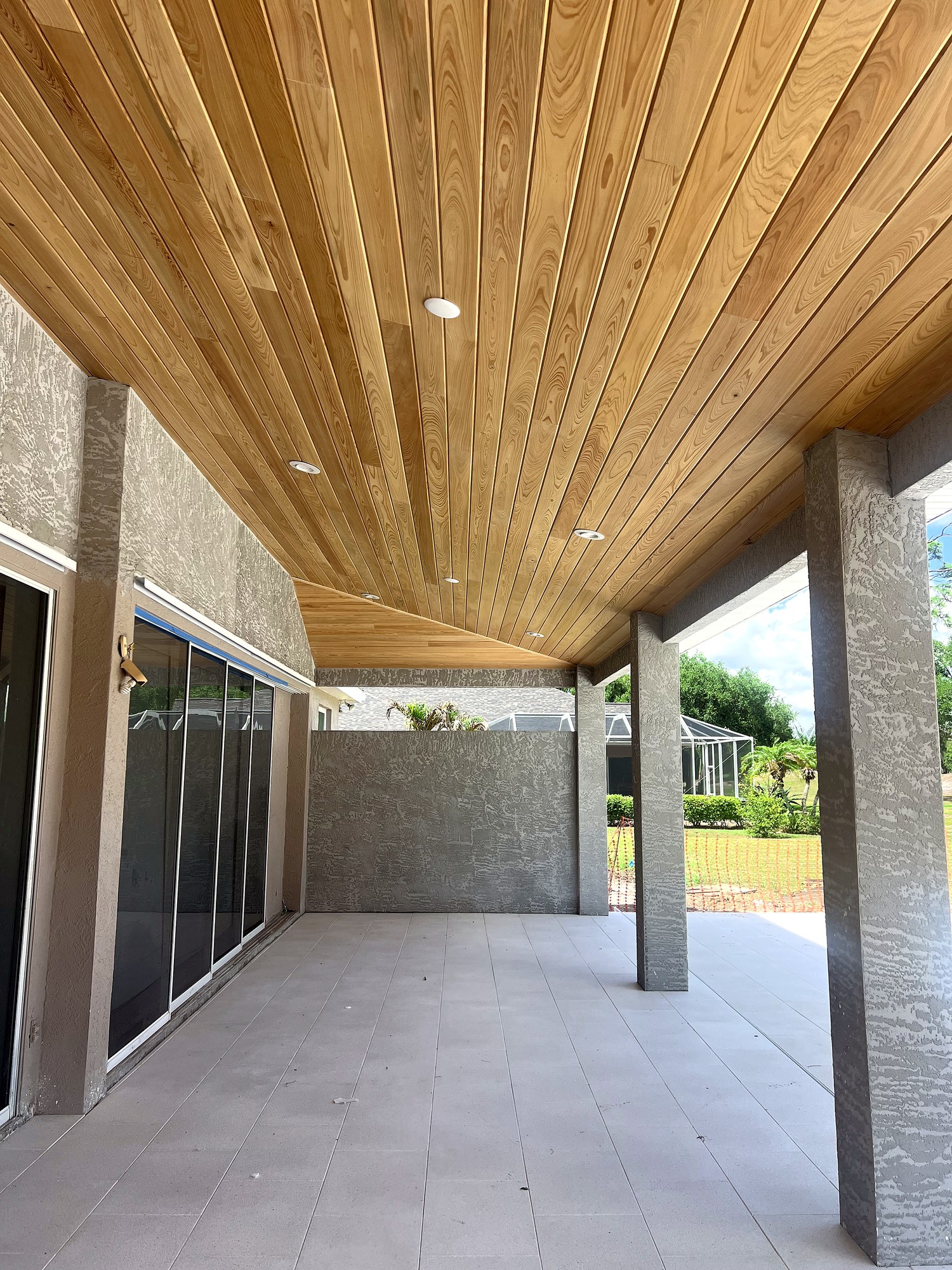 Finished lanai with wood-plank ceiling and paver deck