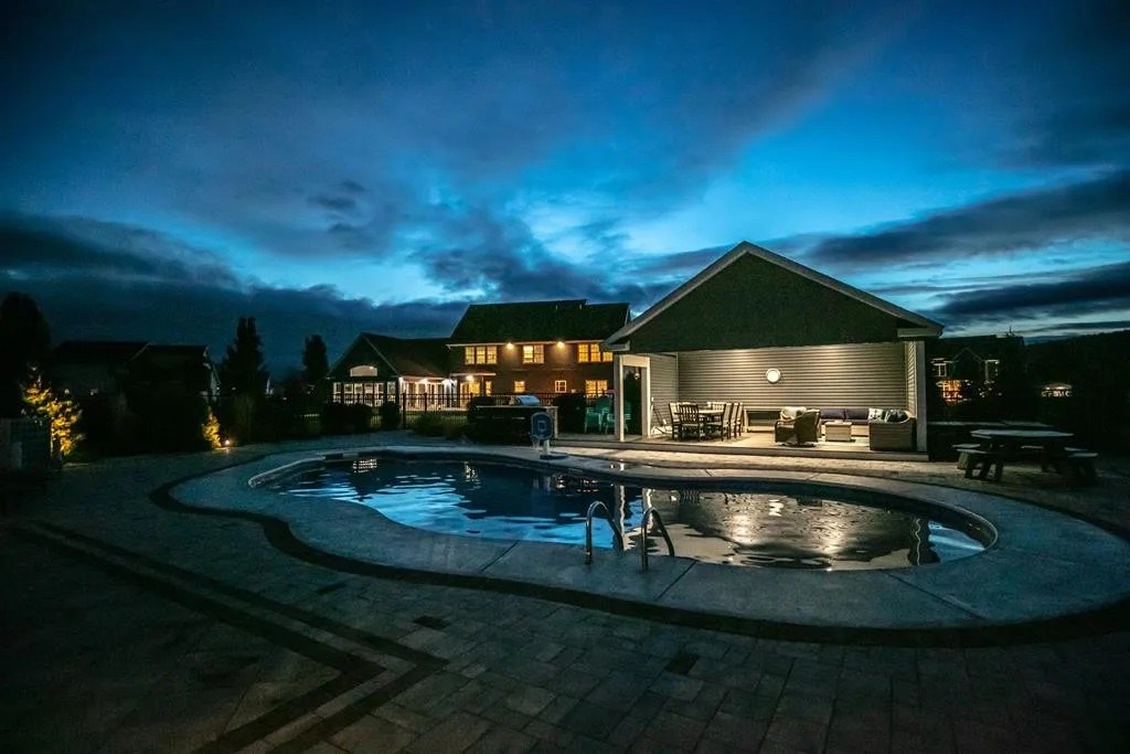 Pool, spa, and covered cabana at twilight
