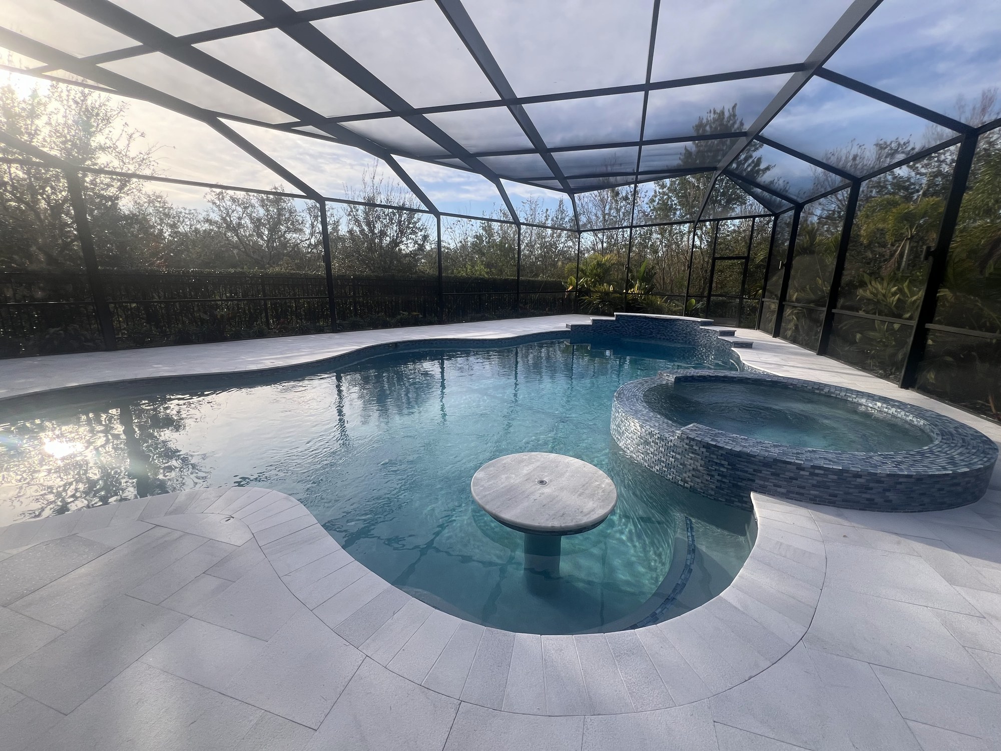 Screened pool and spa with a submerged bar table
