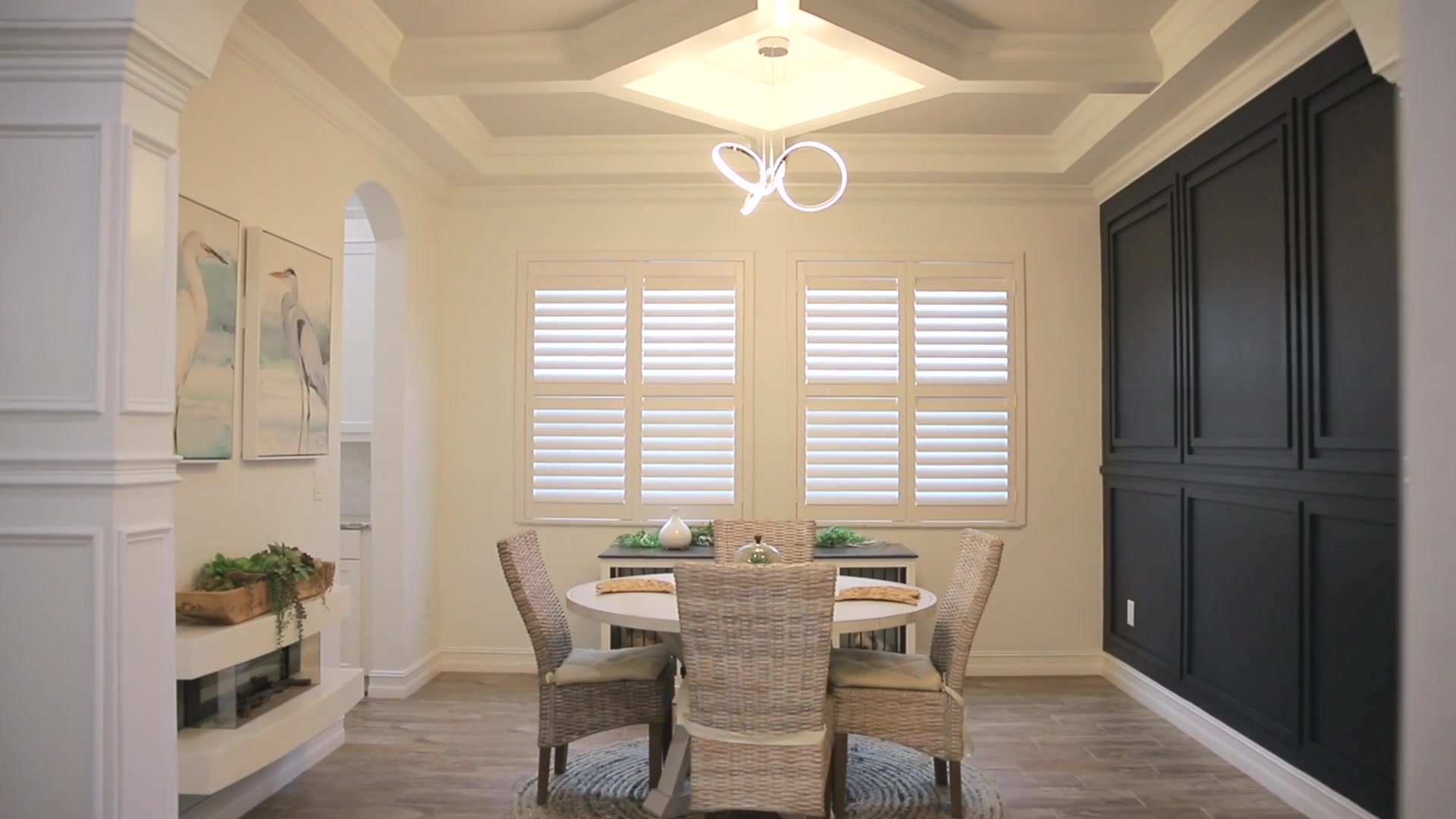 Custom millwork and built-ins including a coffered ceiling, dark accent wall, and staircase woodwork