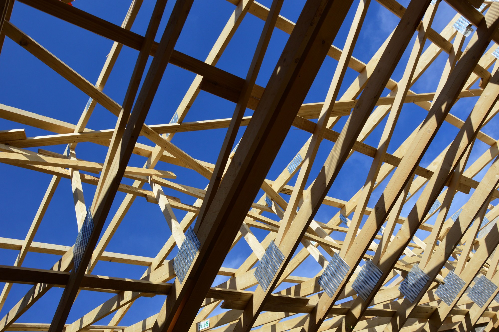 Roof truss framing with structural connector plates during new home construction